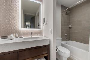 a bathroom with a sink and a toilet and a mirror at Omni Charlotte Hotel in Charlotte