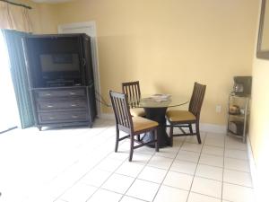 a dining room with a table and chairs and a tv at Coconut Malorie Resort Ocean City a Ramada by Wyndham in Ocean City