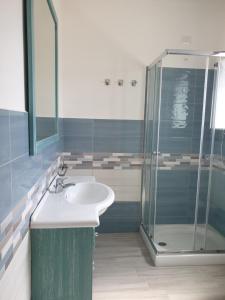 y baño con lavabo y ducha. en Caletta sul Mare en La Caletta