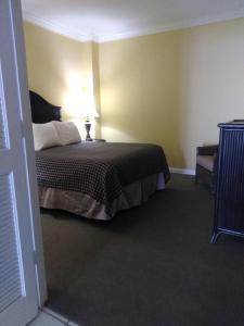 1 dormitorio con 1 cama con lámpara. en Coconut Malorie Resort Ocean City a Ramada by Wyndham, en Ocean City