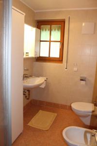 baño con lavabo y aseo y ventana en Beikircherhof, en San Lorenzo di Sebato