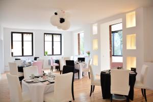 a dining room with white tables and white chairs at Logis Du Haut-Koenigsbourg in Thannenkirch