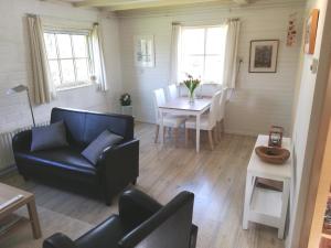 a living room with a black chair and a table at Sluizeweidje Texel in Den Burg