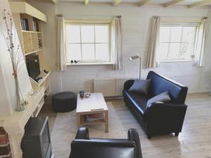 a living room with a couch and a table at Sluizeweidje Texel in Den Burg