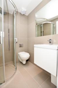 a bathroom with a toilet and a sink and a shower at Kings Cross Serviced Apartments by Concept Apartments in London