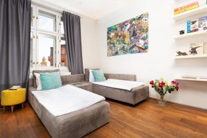 uma sala de estar com duas camas e um sofá em Designer Vinohrady Apartments em Praga