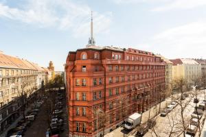 um grande edifício de tijolos vermelhos em uma cidade em Designer Vinohrady Apartments em Praga