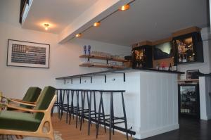 a bar with green chairs and a counter in a room at Hotel Dylan in Woodstock