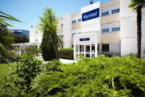 un bâtiment avec un panneau sur son côté dans l'établissement Kyriad Toulon Est Hyeres La Garde, à La Garde