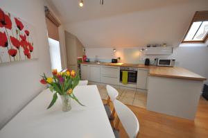 uma cozinha com uma mesa com um vaso de flores em The Coach House Studio Apartment em Leamington Spa