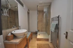 uma casa de banho com um lavatório branco e um chuveiro em The Coach House Studio Apartment em Leamington Spa