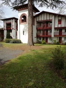 a large building with a tree in front of it at Residence Parc Arradoy in Saint-Jean-Pied-de-Port