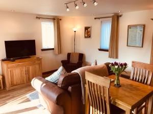 uma sala de estar com um sofá e uma mesa em Courtyard Bothy em Grantown-on-Spey