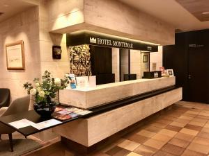 a hotel lobby with a reception counter with flowers at Montemar in Llanes