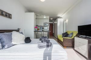 ein Schlafzimmer mit einem großen Bett und ein Wohnzimmer in der Unterkunft Apartamentos Estudio Nuevo en Puerto de la Cruz in Puerto de la Cruz