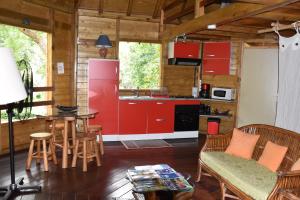 a kitchen with red cabinets and a table and chairs at Gite du Manial in Pointe-Noire