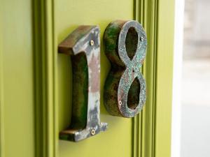 un verrou de porte métallique portant un symbole sur une porte verte dans l'établissement Number 18, à Conwy