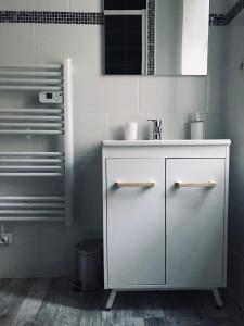 baño con armario blanco y lavamanos en Appartement standing, en Nevers