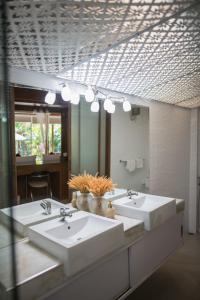 La salle de bains est pourvue de 3 lavabos et d'un grand miroir. dans l'établissement Pratumnak Soi 5 Bungalow I, à Pattaya (sud)