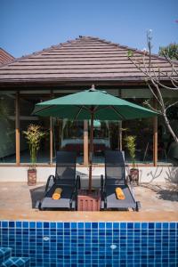 - deux chaises et un parasol vert à côté de la piscine dans l'établissement Pratumnak Soi 5 Bungalow I, à Pattaya (sud)
