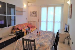 ein Wohnzimmer mit einem Tisch und einem Sofa in der Unterkunft Appartamento Angela in Pietra Ligure