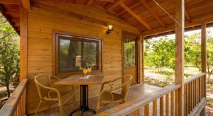 a table and chairs on a porch of a cabin at Secret Garden Hotel & Bungalows in Cıralı