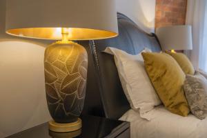 una lámpara sentada en una mesa junto a una cama en ChocoLets - The Lion Suite, en York