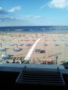 uma vista para uma praia com cadeiras e guarda-sóis em Hotel Giordano Spiaggia em Rimini