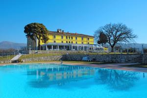 Una gran piscina frente a un edificio amarillo. en Eliceto Resort & SPA, en Buccino