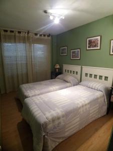 - 2 lits dans une chambre aux murs verts dans l'établissement Bonito Apartamento con varias piscinas, à Salou