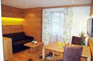 a living room with a table and a couch at Hotel LENAUHOF - nur 3 Minuten zur Rottal Terme - in Bad Birnbach