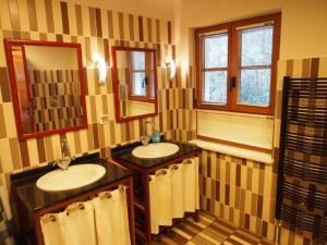 a bathroom with two sinks and a mirror at Der Fuchsbau in Meesiger +23 photos