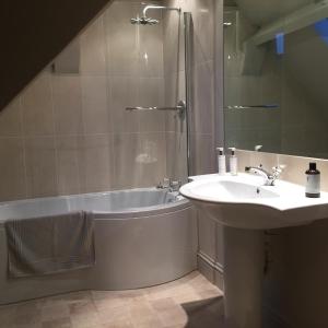 a bathroom with a tub and a sink and a shower at School House in Malmesbury