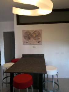 een eetkamer met een zwarte tafel en krukken bij Appartamento nel Cuore della Valpolicella in San Pietro in Cariano