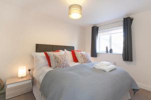 a bedroom with a bed with pillows and a window at DBS Serviced Apartments - The Terrace in Castle Donington