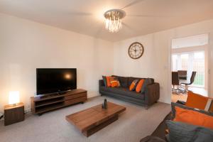 a living room with a couch and a flat screen tv at DBS Serviced Apartments - The Terrace in Castle Donington