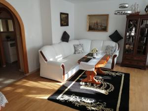 a living room with a white couch and a table at Apartament Paradise in Międzyzdroje
