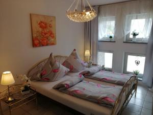 two beds in a bedroom with windows and a chandelier at Apartament Paradise in Międzyzdroje