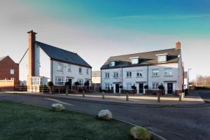 a group of white buildings on a street at DBS Serviced Apartments - The Terrace in Castle Donington