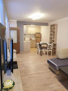 a living room and kitchen with a couch and a table at Хепи Апартмънтс in Plovdiv