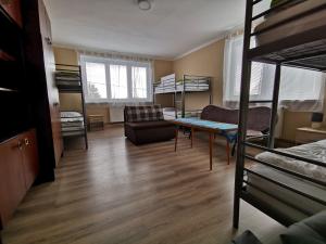 a room with bunk beds and a table and a couch at U Vrbů in Vrbovec