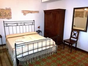 a bedroom with a bed and a mirror and a chair at Li Traìni in San Pietro in Lama