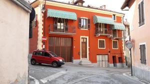 a red car parked in front of an orange building at B&B del Borgo in Mondovì