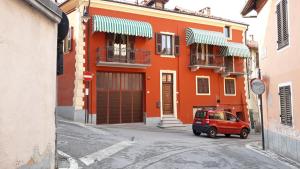 モンドヴィにあるB&B del Borgoのオレンジ色の建物の前に停車した赤い車