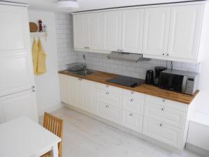 cocina con armarios blancos y microondas en Townhouse Lund, en Lund