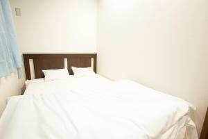 大阪市にある123 ゲストハウスの白いベッド1台(枕2つ付)