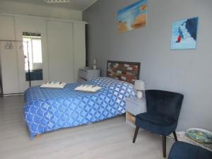 a bedroom with a blue bed and a chair at l'Orchidée in Andernos-les-Bains