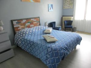 a bedroom with a bed with a blue comforter at l'Orchidée in Andernos-les-Bains