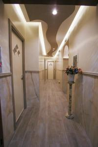 un corridoio con una stanza con un vaso di fiori di Hotel Iris a Napoli
