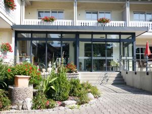 um edifício com plantas e flores à sua frente em Hotel Lenauhof em Bad Birnbach
